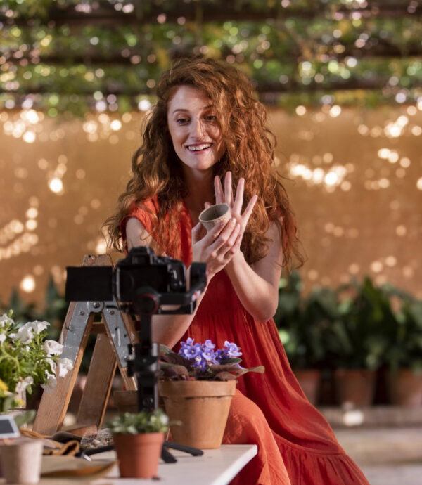 A creator smiling at her camera while filming content